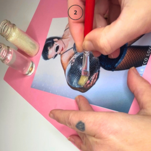 Påføring av lim før glitter brukes på bilde eller kunstverk